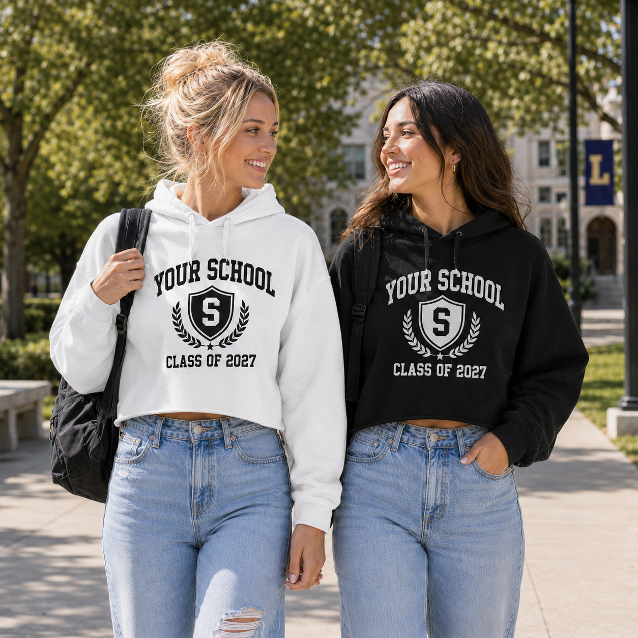 Two students wearing personalized black and white cropped hoodies on campus